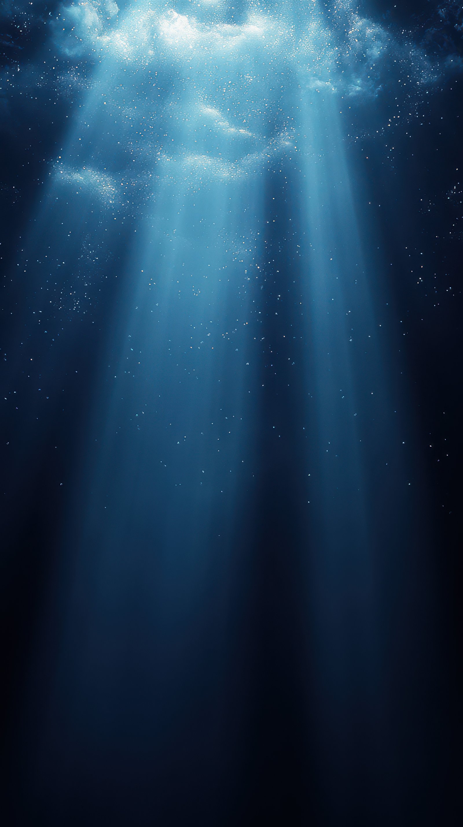 Beautiful underwater rays of light illuminating the depths of the ocean at twilight, creating a serene and mystical atmosphere